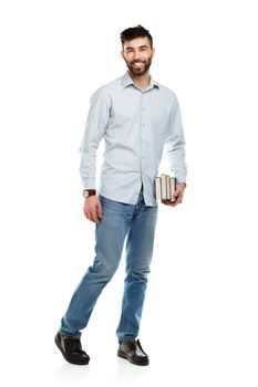 Young bearded smiling man with books in hands on white background