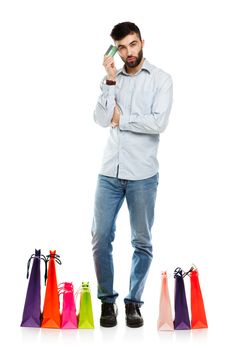 Handsome smiling man with shopping bags and holding credit card. Christmas and holidays concept