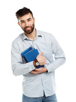 Young bearded smiling man with books in hands on white background