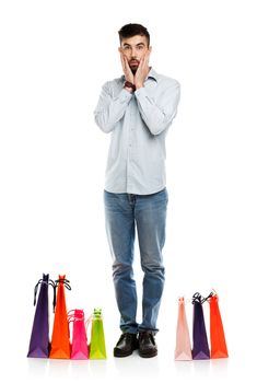 Handsome man with shopping bags is shocked. Christmas and holidays concept