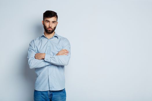 A young bearded man with a serious expression on his face