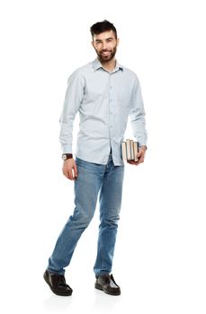 Young bearded smiling man with books in hand on white background