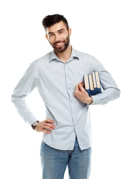 Young bearded smiling man with books in hand on white background