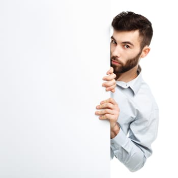 A young bearded man showing blank signboard, isolated over white background