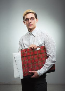 Young serious man in glasses with a red drawing folder in hands