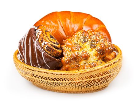 Fresh and tasty buns with with sesame and poppy seeds, bagel with jam and roll with chocolate in a basket over white background