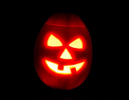 Halloween pumpkin jack-o-lantern candle lit, isolated on black background