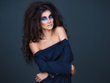 Portrait of a young beautiful girl with a fashion dark  makeup of eyes and and bulk hair