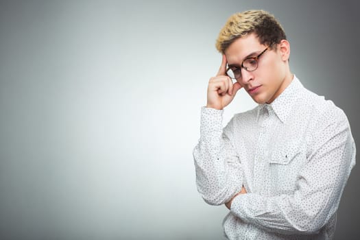 Young man with glasses thinking