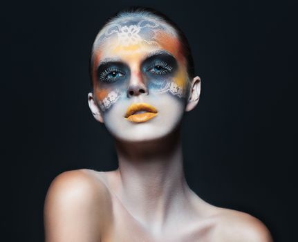 Portrait of beautiful glamor girl with dark eye make-up in the form of lace and orange lips on black