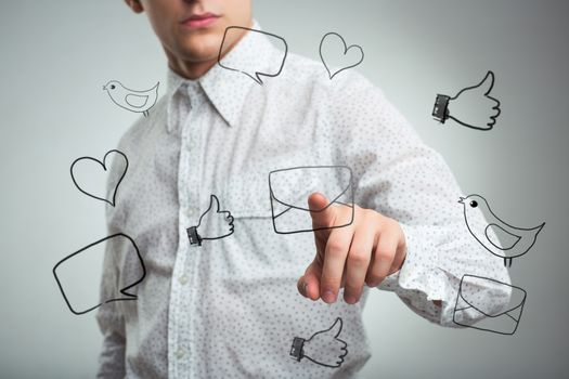 Young man pressing a virtual icon mail in air