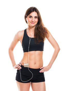 Beautiful slim woman listening to music while exercising on a white background