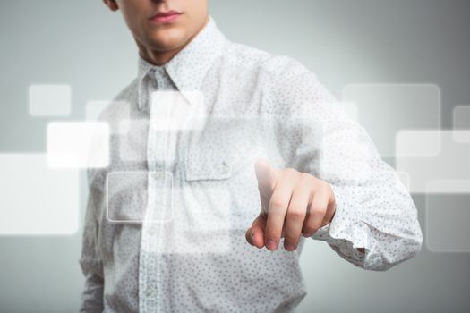 Young businessman pressing application button on computer with touch screen