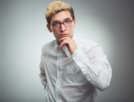 Young serious man looking to the camera wearing glasses