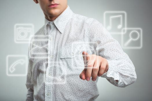 Young businessman pressing application button on computer with touch screen