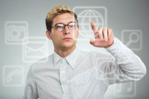 Young businessman pressing application button on computer with touch screen