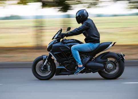 Young man riding a sport motorcycle on the road