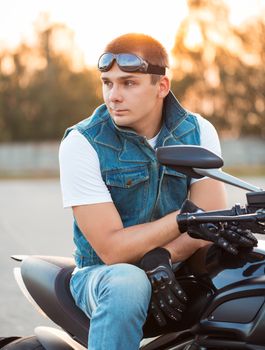 Biker man  sitting on his motorcycle outdoors