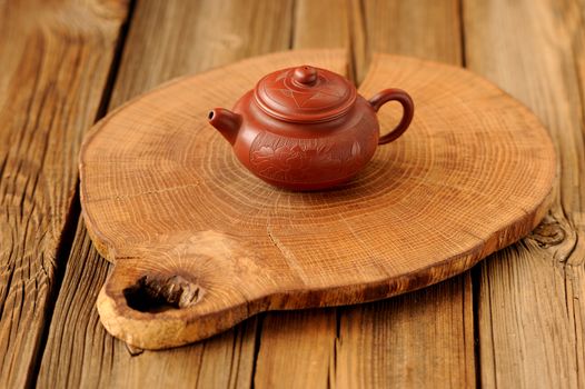 Small yixing red clay teapot on wooden board horizontal