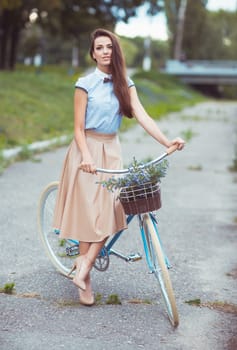 Young beautiful, elegantly dressed woman with bicycle, summer and lifestyle