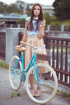 Young beautiful, elegantly dressed woman with bicycle, summer and lifestyle