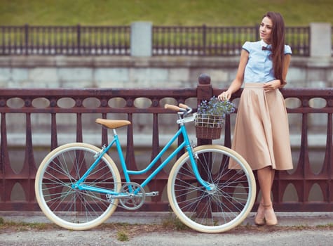 Young beautiful, elegantly dressed woman with bicycle, summer and lifestyle