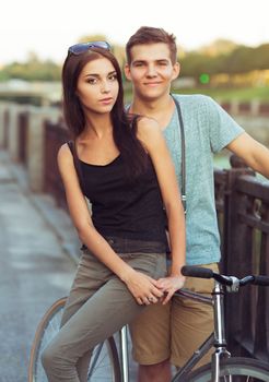 Happy couple - man and woman with bike in the city