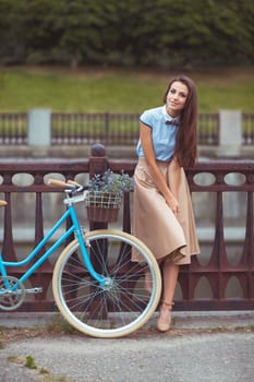 Young beautiful, elegantly dressed woman with bicycle. Beauty, fashion and lifestyle