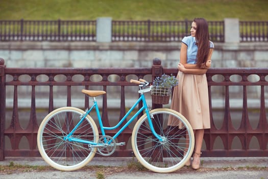 Young beautiful, elegantly dressed woman with bicycle. Beauty, fashion and lifestyle