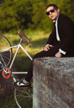 Young stylish guy with fixed gear bicycle outdoors