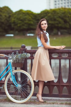 Young beautiful, elegantly dressed woman with bicycle. Beauty, fashion and lifestyle