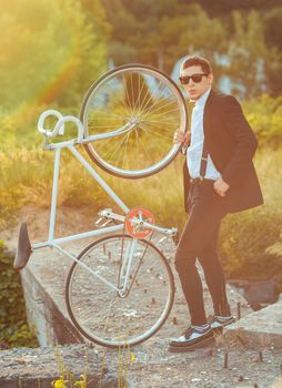 Young stylish guy with fixed gear bicycle outdoors