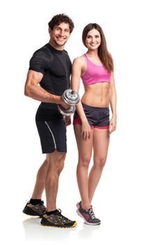 Athletic couple - man and woman with dumbbells on the white background