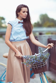 Young beautiful, elegantly dressed woman with bicycle, summer and lifestyle