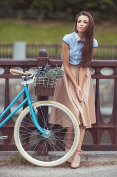 Young beautiful, elegantly dressed woman with bicycle, summer and lifestyle