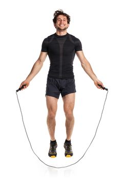 Athletic attractive man jumping on a rope on the white background