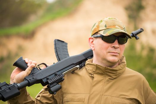 Man in camouflage with a shotgun outdoor