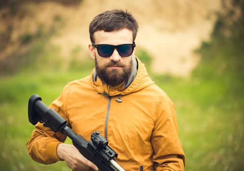 A man with an automatic rifle outdoor