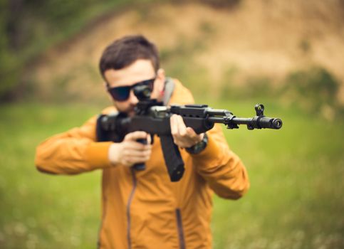 A man with an automatic rifle outdoor