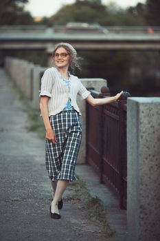 Funny girl with glasses and a vintage dress outdoors