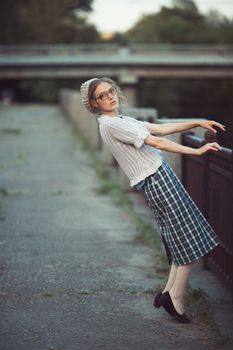 Funny girl with glasses and a vintage dress outdoors