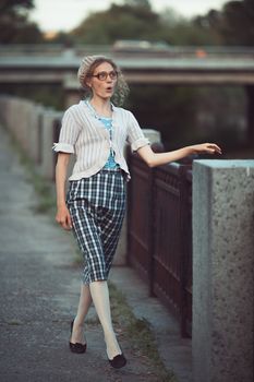 Funny girl with glasses and a vintage dress outdoors