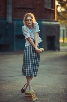 Funny girl student with glasses and a vintage dress outdoors