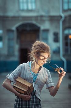 Funny girl student with glasses and a vintage dress outdoors