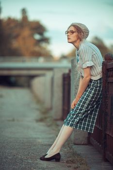 Funny girl with glasses and a vintage dress outdoors