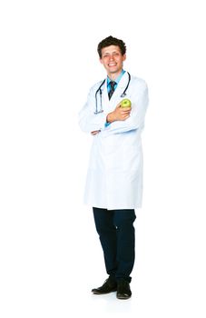 Portrait of a smiling male doctor holding green apple on white background