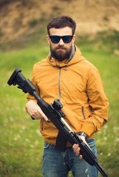 A man with an automatic rifle outdoor