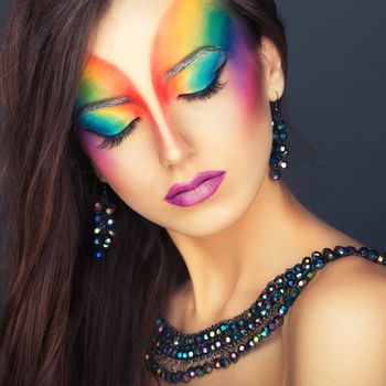 Portrait of a young beautiful girl with a fashion bright multicolored makeup of eyesyes
