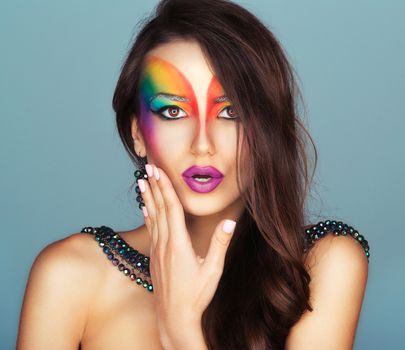 Portrait of a young beautiful girl with a fashion bright multicolored makeup of eyes