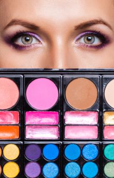 Closeup of beautiful womanish eyes with makeup kit and glamorous makeup